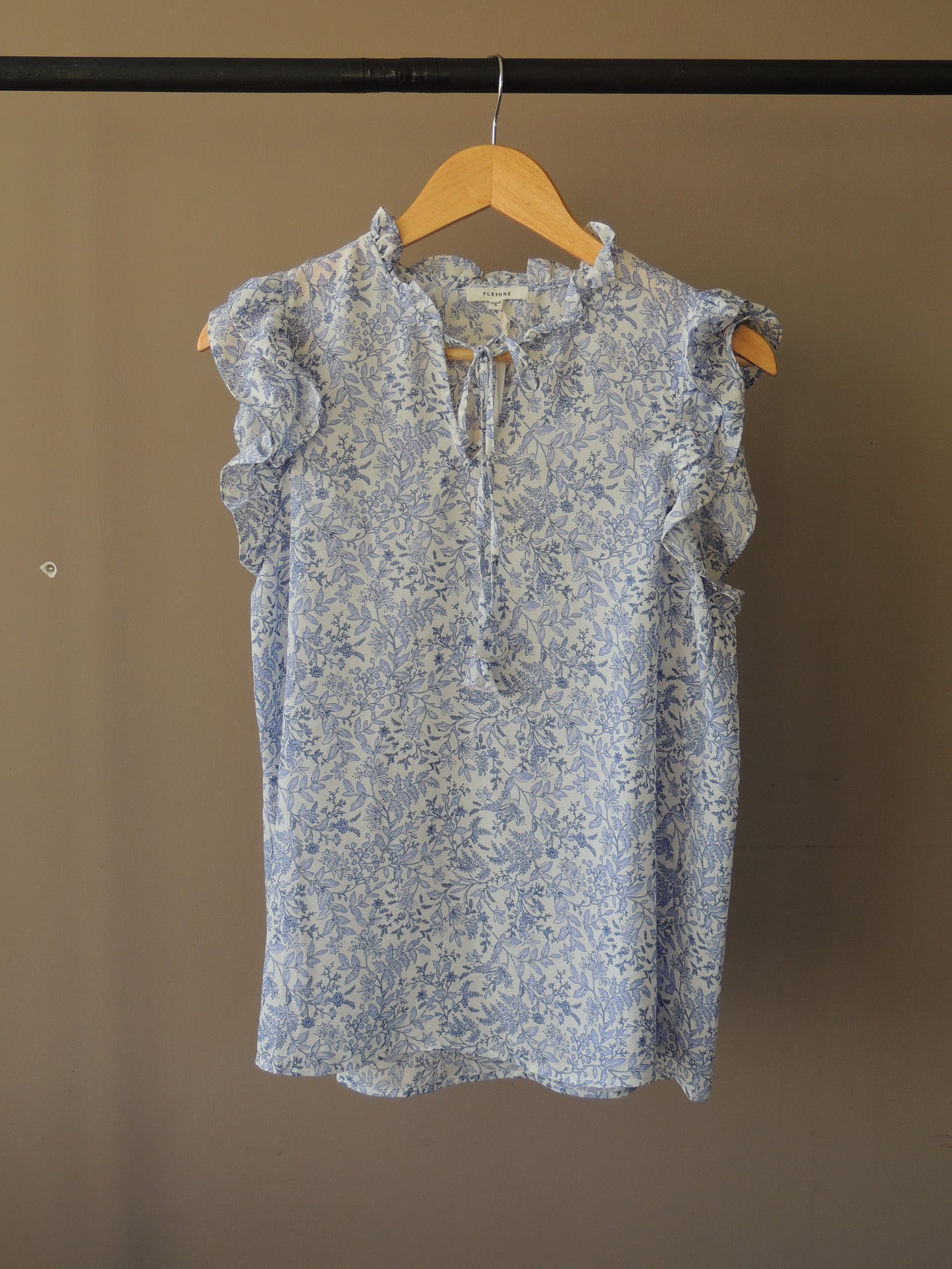 Blusa Pleione, con motivo floral en celeste, bolados y lazo, talle M, con etiqiueta