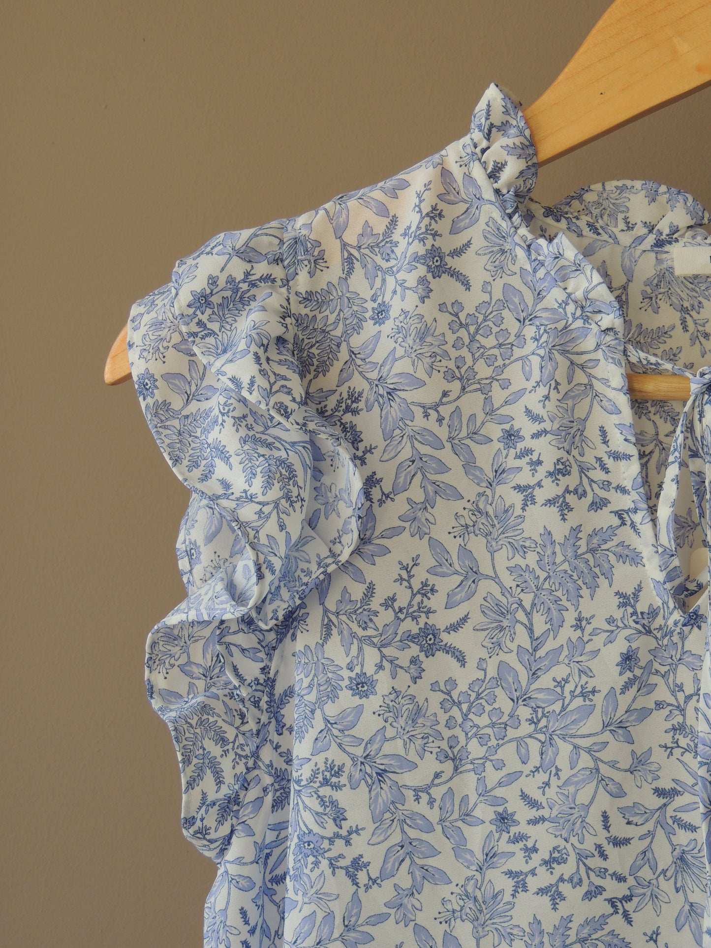 Blusa Pleione, con motivo floral en celeste, bolados y lazo, talle M, con etiqiueta
