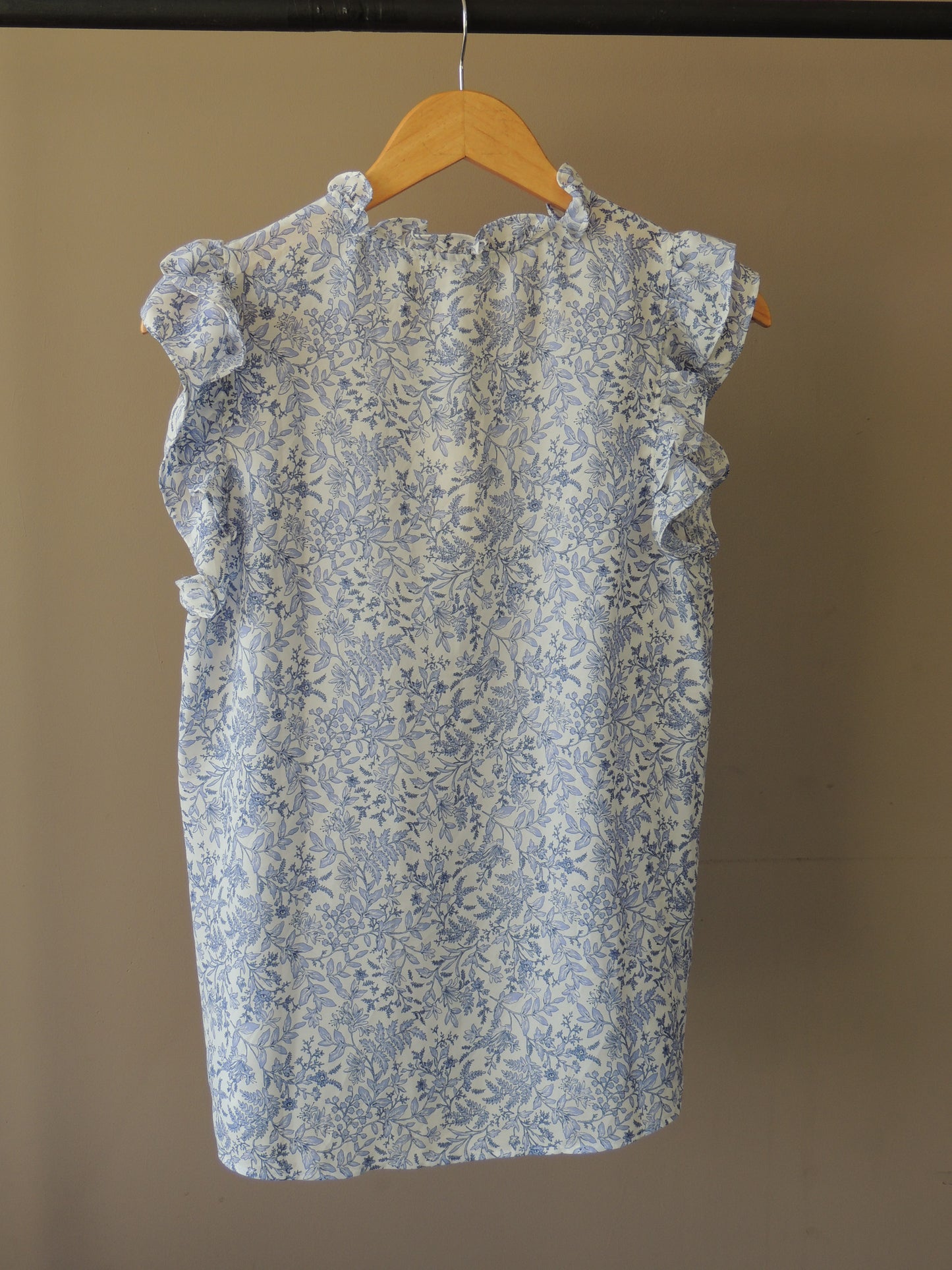 Blusa Pleione, con motivo floral en celeste, bolados y lazo, talle M, con etiqiueta