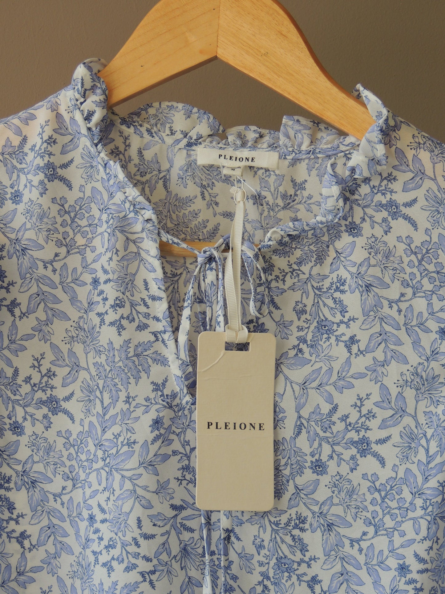 Blusa Pleione, con motivo floral en celeste, bolados y lazo, talle M, con etiqiueta